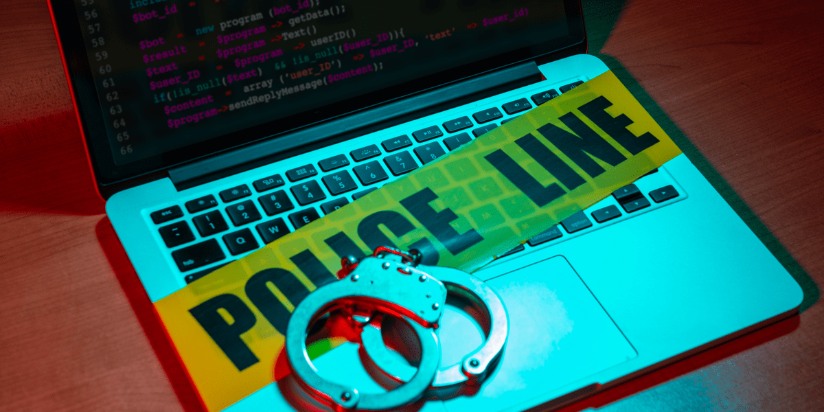 Laptop taken as digital evidence source by police forces with handcuffs placed on it